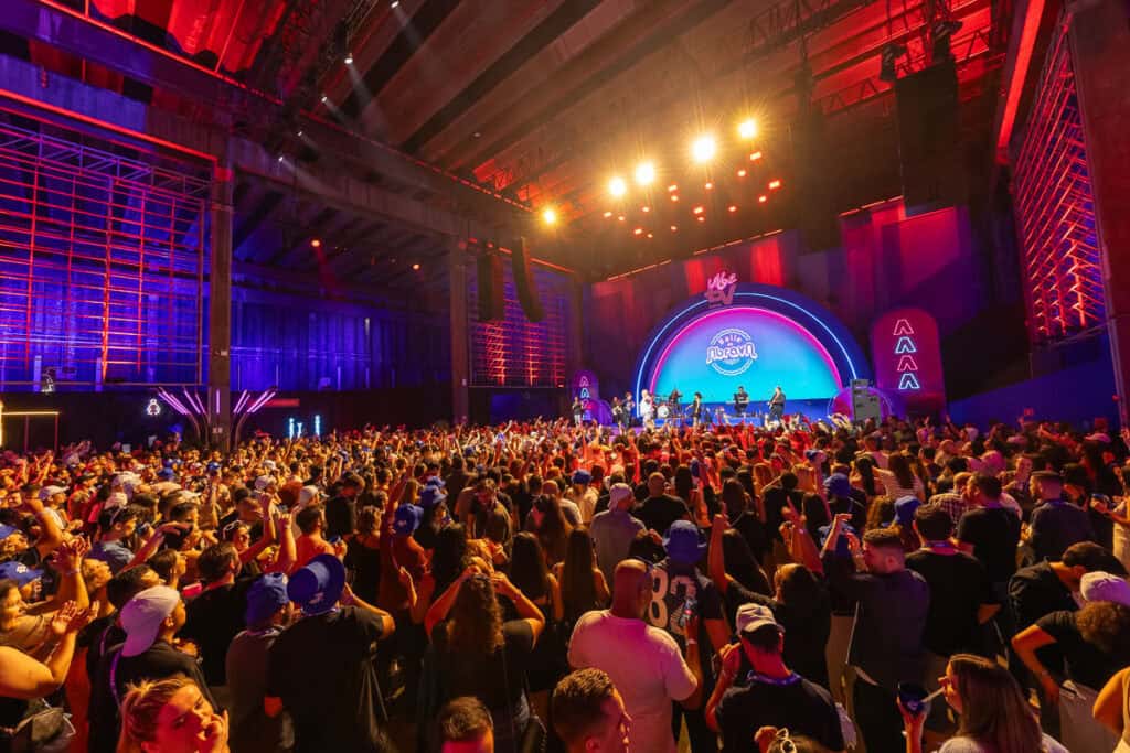 Evento musical ao vivo com grande público em espaço fechado.