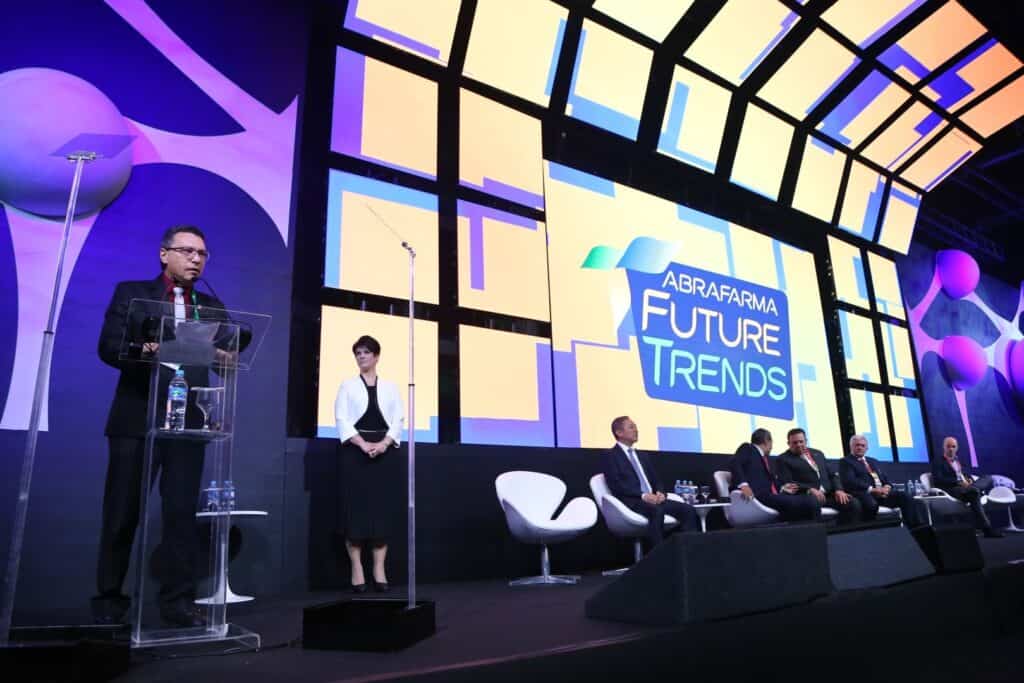 Palestrante apresentando tendências futuras do mercado de varejo em evento com painel de especialist.