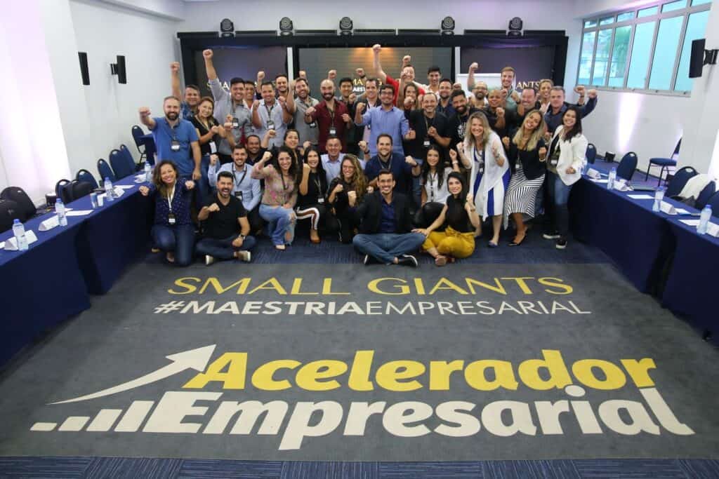 Imagem de grupo com profissionais em evento de negócios, celebrando sucesso empresarial.